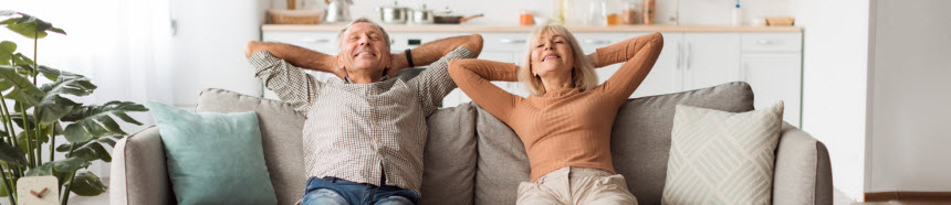 Happy Senior Couple Relaxing Sitting On Sofa At Home