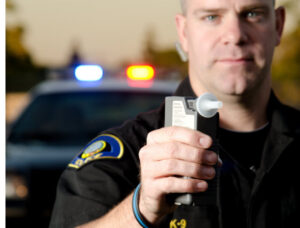 male police officer holding a breathlyers
