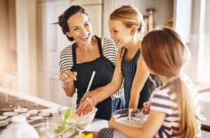 mom with her two young daughter baking in their kitchen